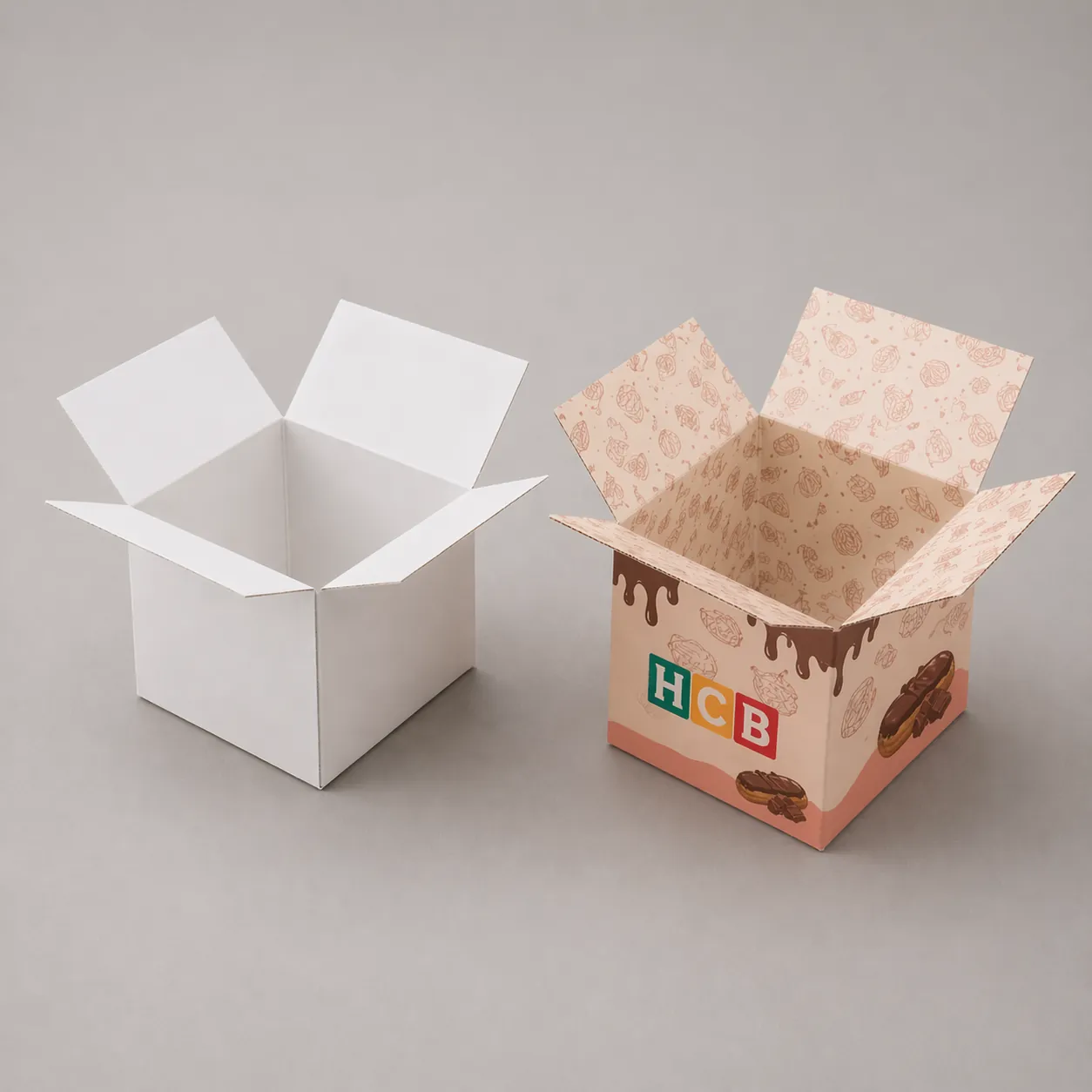 A slim white retail box next to a custom printed box showing delicious pastry graphics. class=